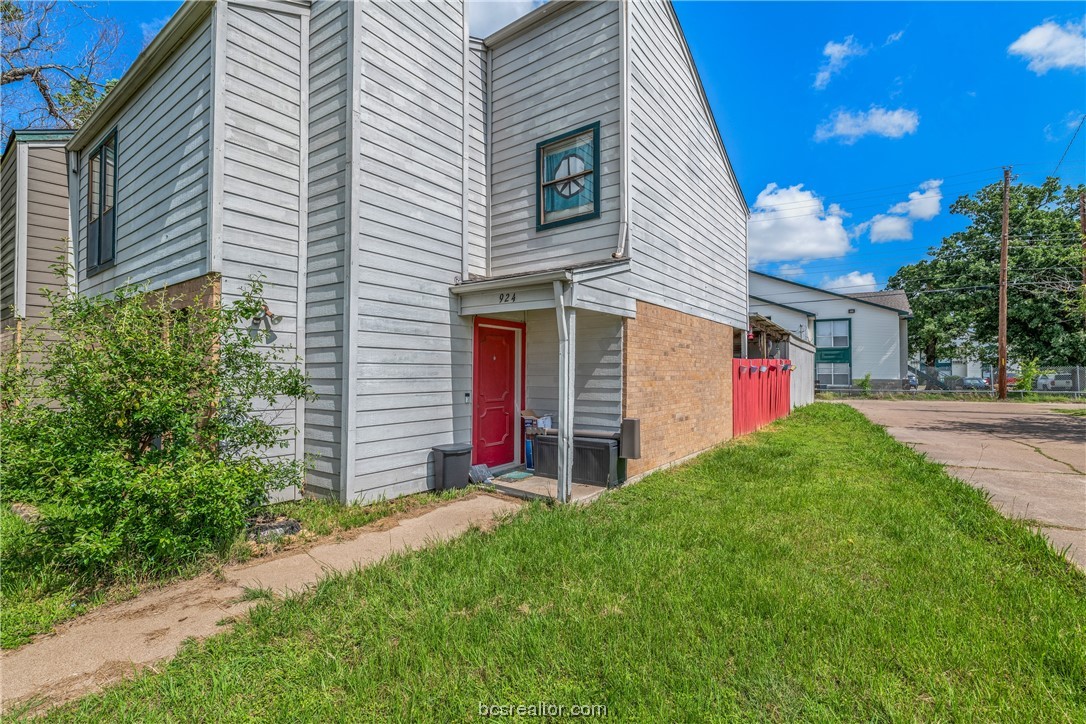 a view of a house with a small yard and a garage