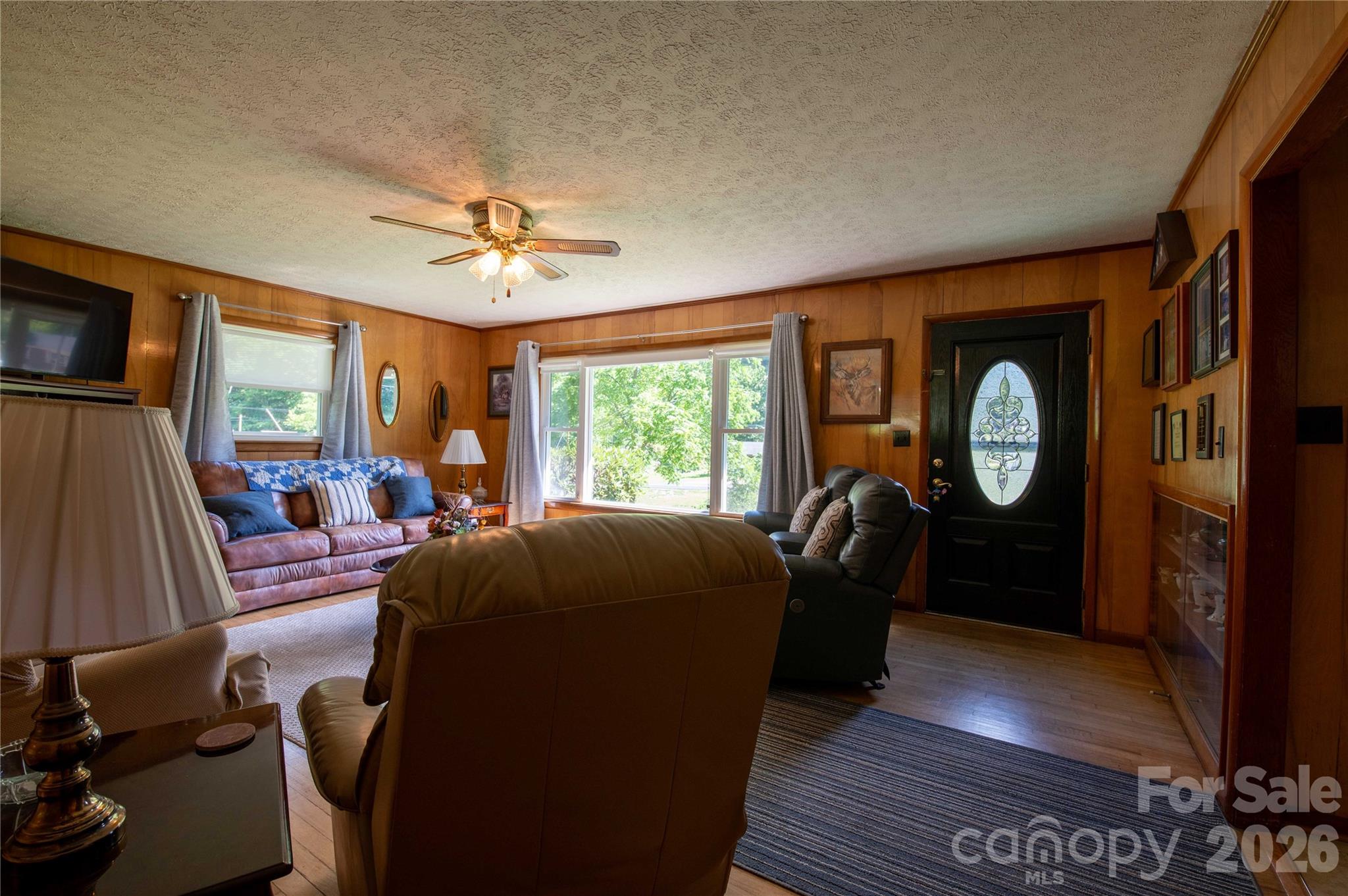 40 Double Island Road Burnsville, NC 28714 - Photo 14 of 38 a living room with furniture a fireplace and a floor to ceiling window