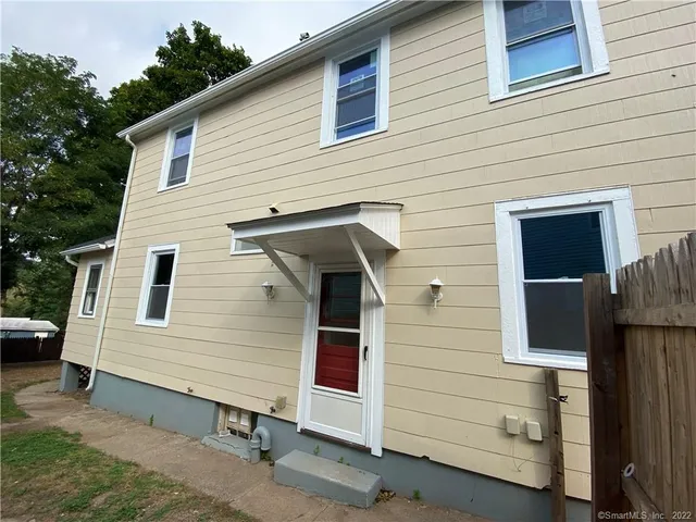 a view of a small house and a garage