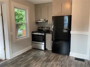 a kitchen with a refrigerator and a stove top oven