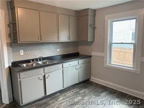 a kitchen with granite countertop white cabinets and sink