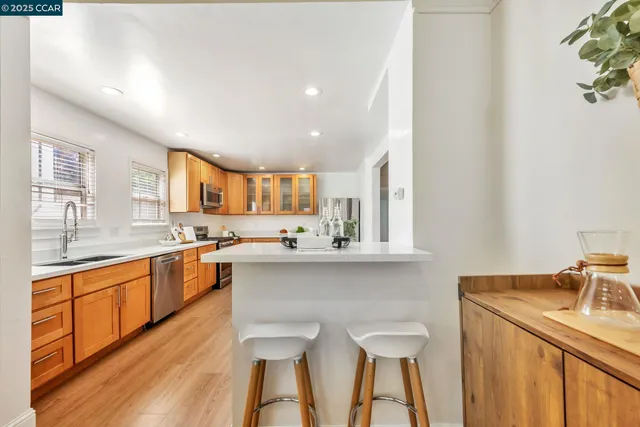 a kitchen with stainless steel appliances a sink stove and wooden floor
