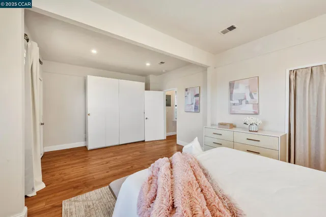 a spacious bedroom with a bed and a view of bathroom