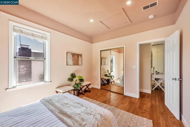 a view of a bedroom with wooden floor and windows