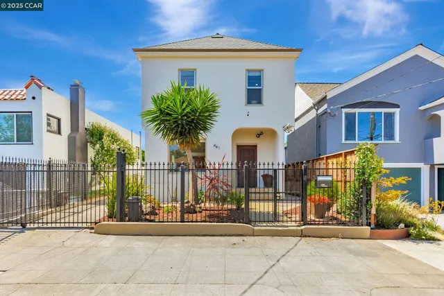 a front view of a house with glass windows and plants