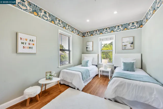 a bedroom with two beds and a large window