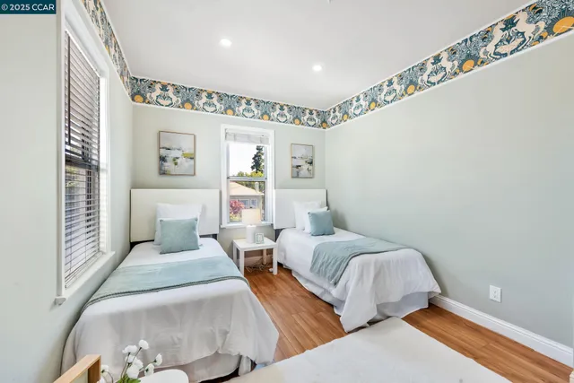 a bedroom with two beds and a large window