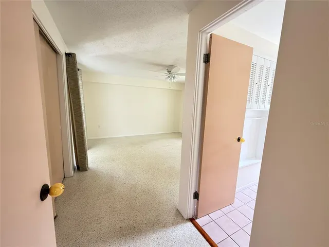 an empty room with fan and windows