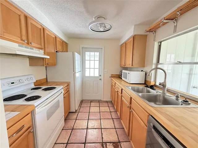 a kitchen with a sink stove top oven and cabinets
