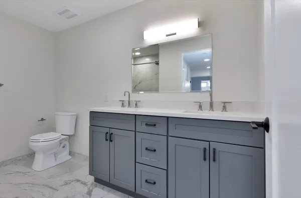 a bathroom with a toilet sink and mirror