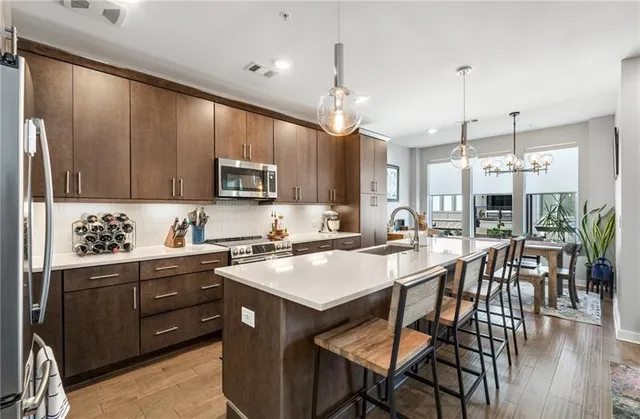 a kitchen with granite countertop a stove a sink a dining table and chairs
