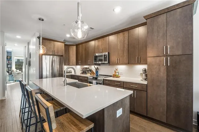 a kitchen with kitchen island a sink stove and refrigerator