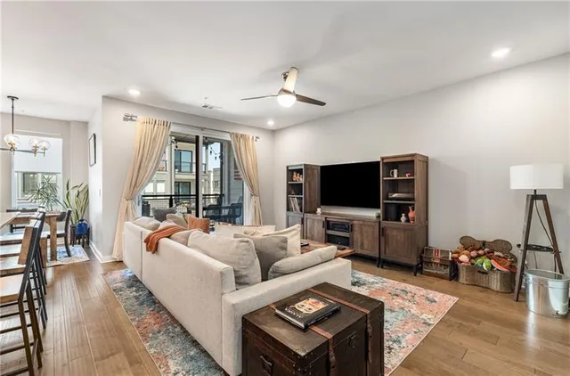 a living room with furniture a flat screen tv and a large window