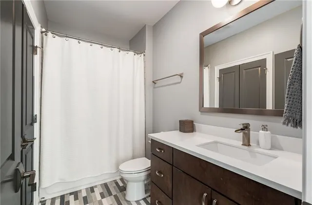 a bathroom with a double vanity sink toilet and a mirror