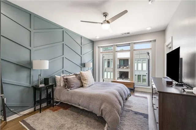a bedroom with a bed window and a flat screen tv