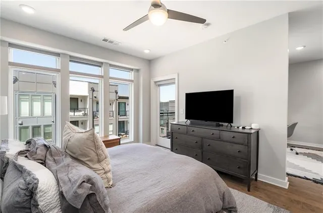 a bedroom with a bed and a flat screen tv on the dresser