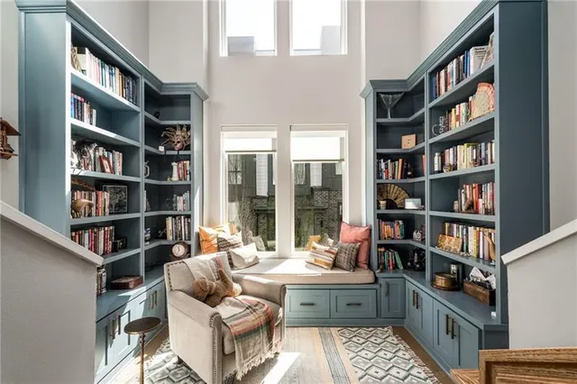 a living room with furniture and a book shelf