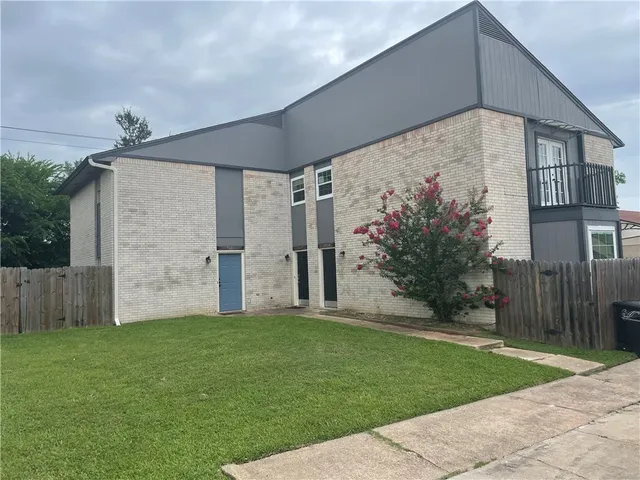 a backyard of a house with potted plants and a yard