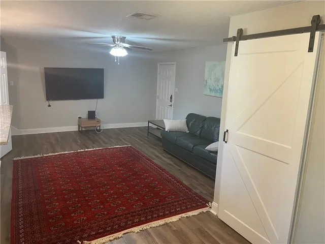 a living room with a bed and a flat screen tv