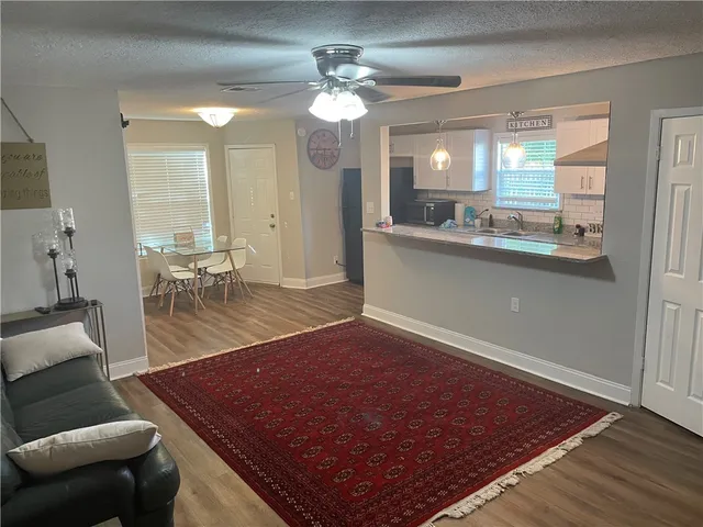 a room with wooden floor pool table and chairs
