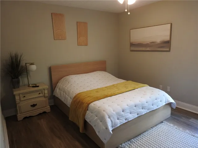 a bed sitting in a bedroom next to a window with dressers