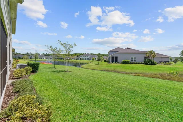 a view of a swimming pool with a yard and large trees