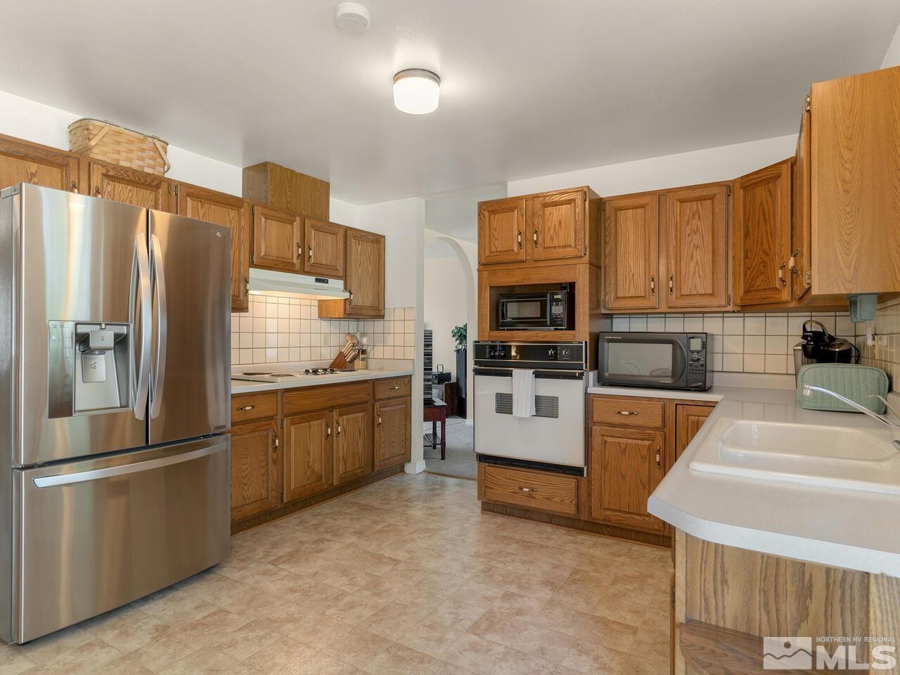 2785 Edgewood Drive Reno, NV 89503 - Photo 11 of 26 a kitchen with stainless steel appliances granite countertop a refrigerator sink and stove