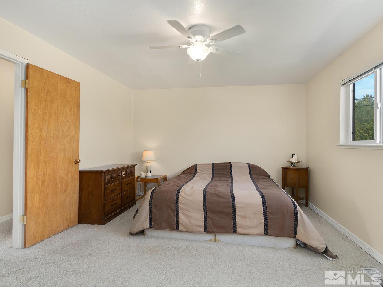 2785 Edgewood Drive Reno, NV 89503 - Photo 17 of 26 a bedroom with a bed and a chandelier