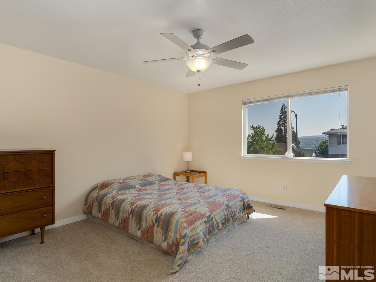 2785 Edgewood Drive Reno, NV 89503 - Photo 19 of 26 a bedroom with a bed and a chandelier