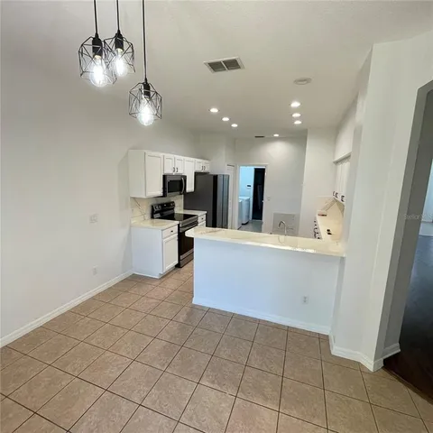 a large kitchen with a stove a sink dishwasher and a refrigerator