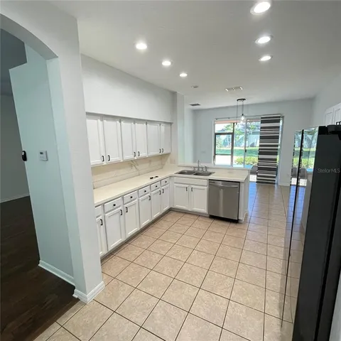 a kitchen with stainless steel appliances kitchen island granite countertop a refrigerator a stove and a sink