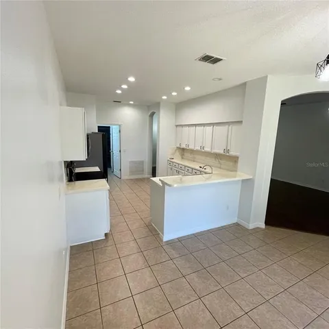 a kitchen with stainless steel appliances a sink a stove a microwave a counter top space and cabinets