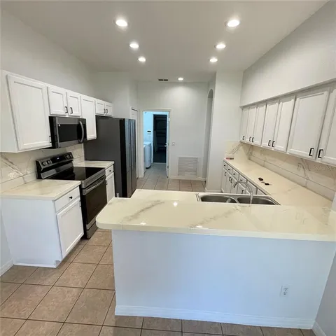 a kitchen with a sink appliances and cabinets