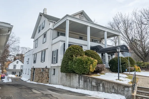 a view of a house with a yard and potted plants