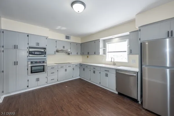 a kitchen with white cabinets and white appliances
