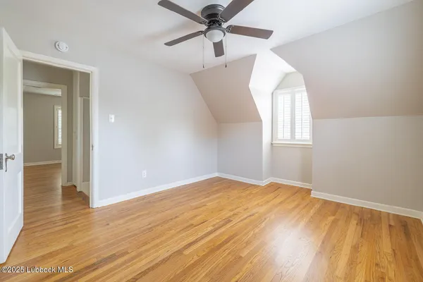 a view of a livingroom with wooden floor and a ceiling fan