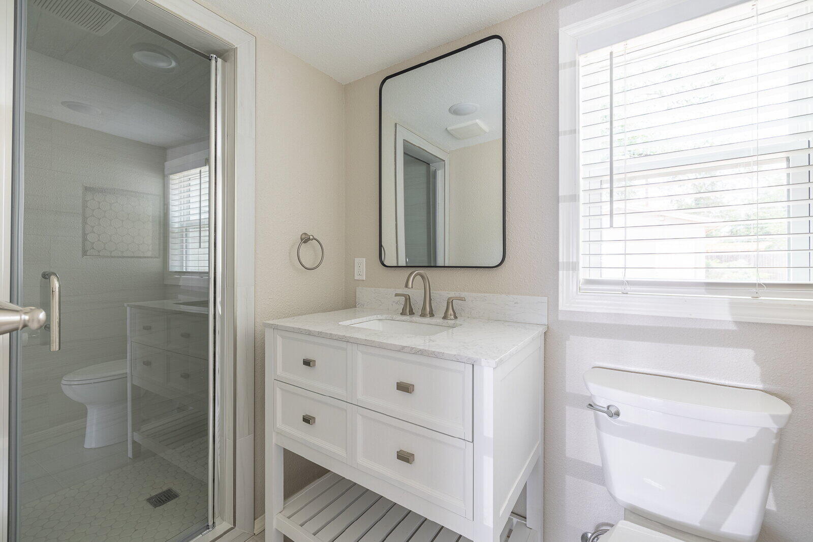 2614 24th Street Lubbock, TX 79410 - Photo 38 of 46 a bathroom with a granite countertop sink a toilet a mirror and shower