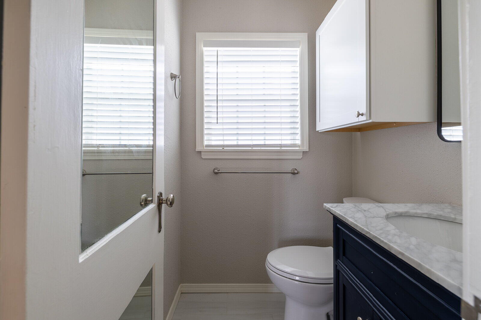 2614 24th Street Lubbock, TX 79410 - Photo 46 of 46 a bathroom with a granite countertop toilet a sink and a window