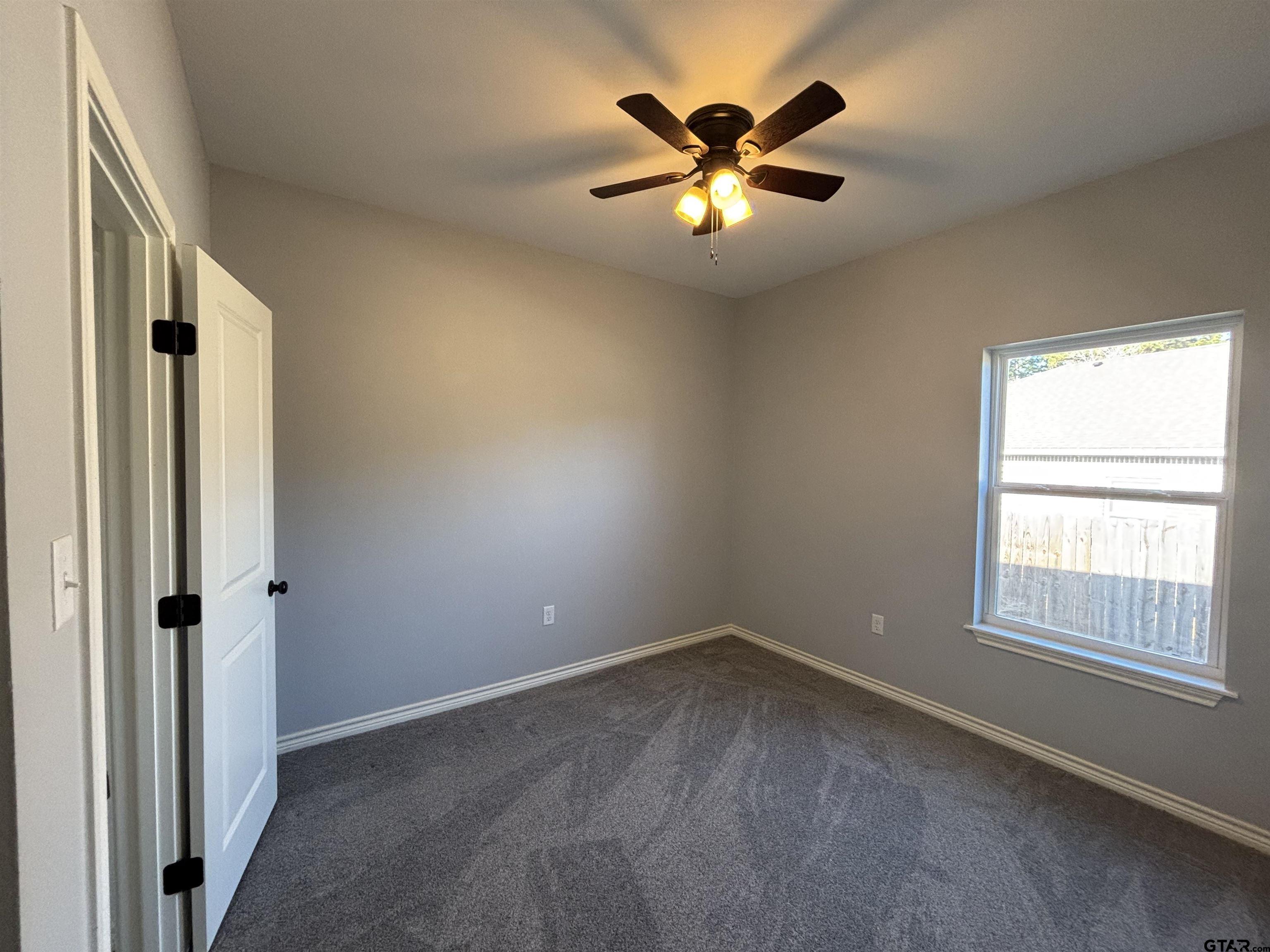 196 Twisted Oaks Road Rusk, TX 75785 - Photo 15 of 25 an empty room with windows and chandelier fan