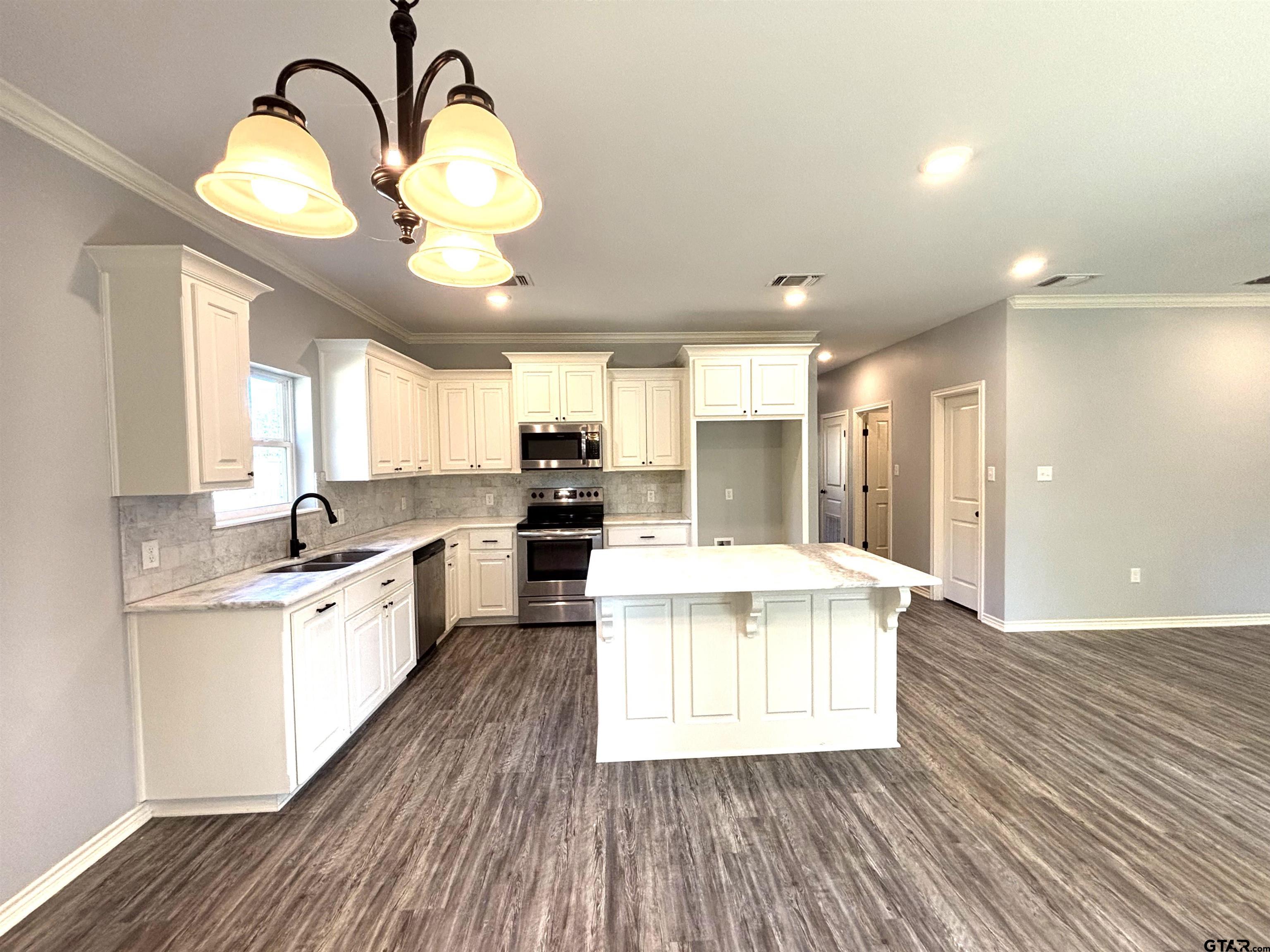 196 Twisted Oaks Road Rusk, TX 75785 - Photo 2 of 25 a large kitchen with kitchen island a large island in the center and stainless steel appliances