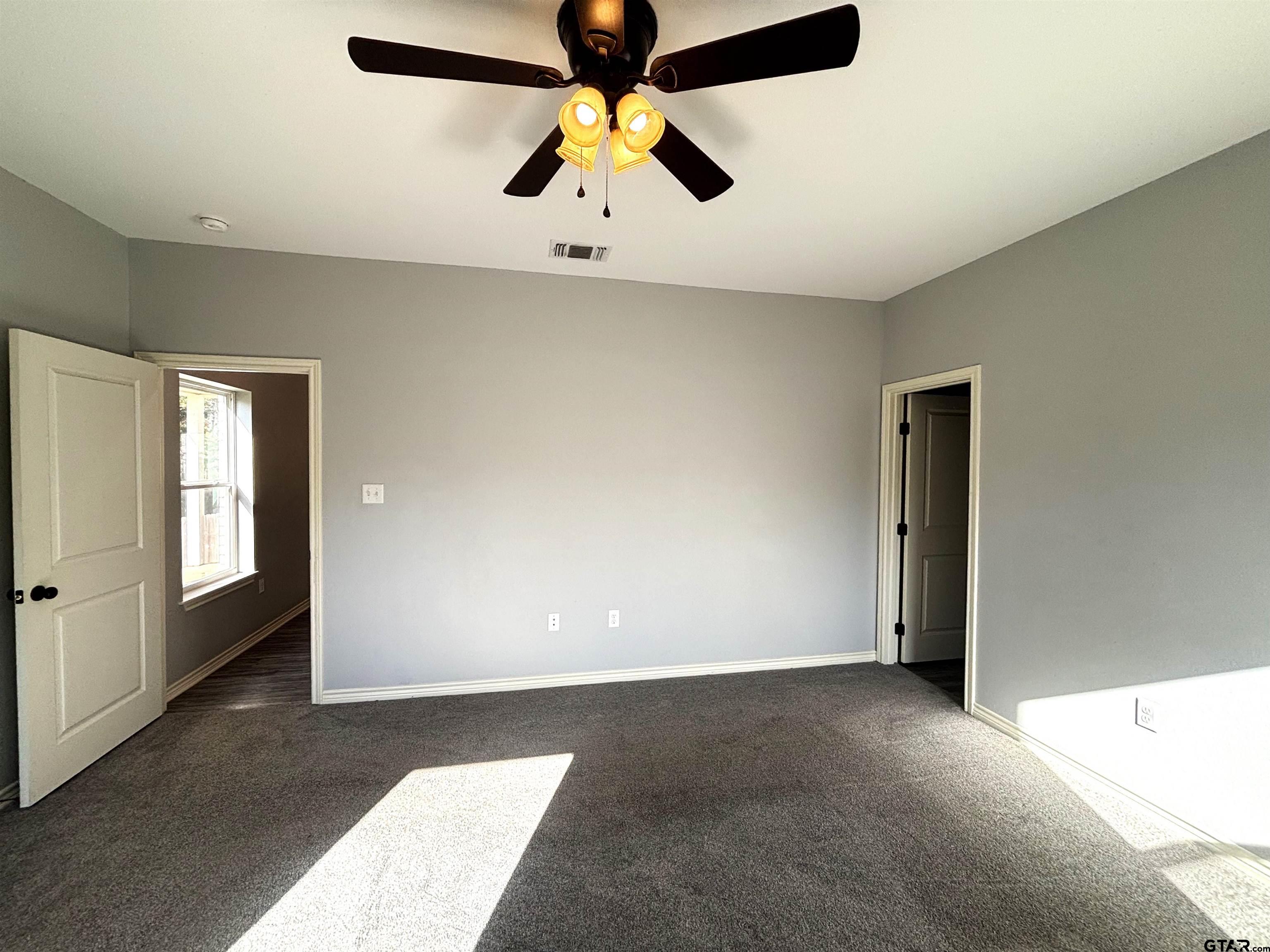 196 Twisted Oaks Road Rusk, TX 75785 - Photo 8 of 25 an empty room with chandelier fan and windows