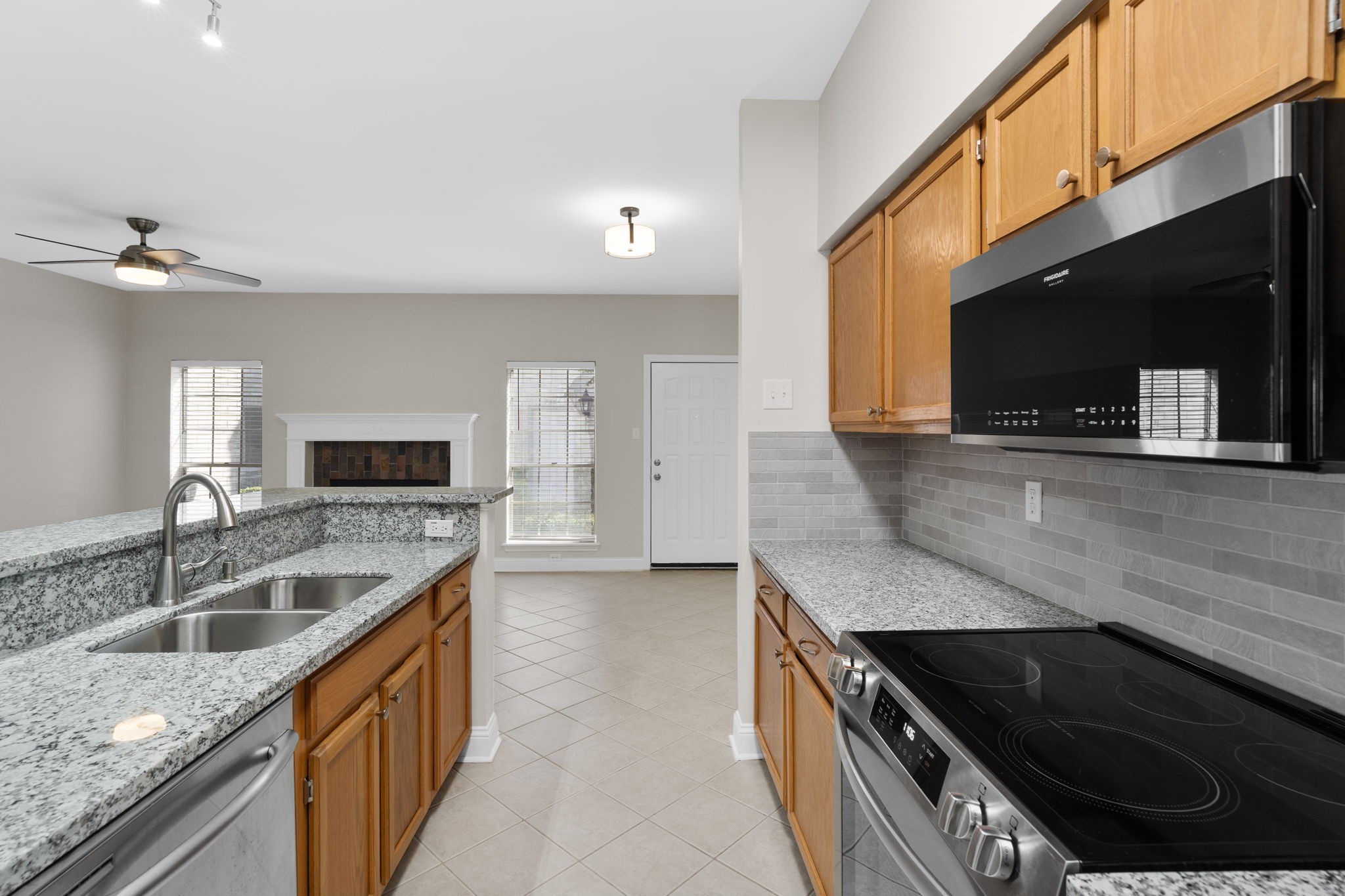 7392 Regency Square Court, Unit 7392 Houston, TX 77036 - Photo 2 of 32 The updated kitchen features granite countertops, a subway tile backsplash, breakfast bar, walk-in pantry, and updated (2024) range and microwave.