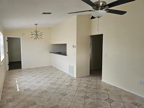 a view of a hallway with a chandelier fan and windows