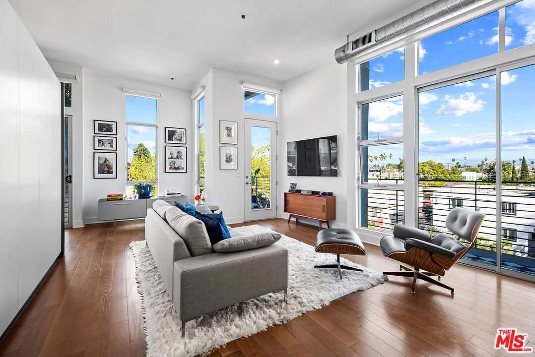 13320 Beach Avenue, Unit 304 Marina del Rey, CA 90292 - Photo 8 of 25 a living room with furniture floor to ceiling window hardwood floor and a flat screen tv