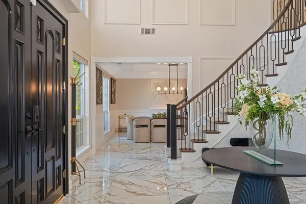 a kitchen with a dining table chairs stove and white cabinets