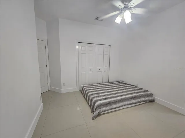 a bedroom with a bed and a chandelier fan