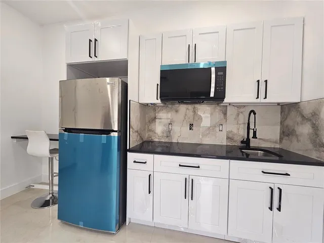 a kitchen with stainless steel appliances white cabinets and a refrigerator