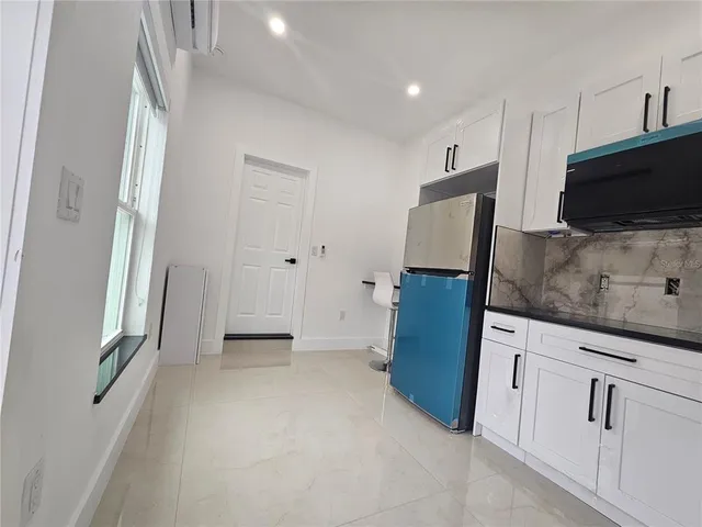 a view of a kitchen with cabinets wooden floor and electronic appliances