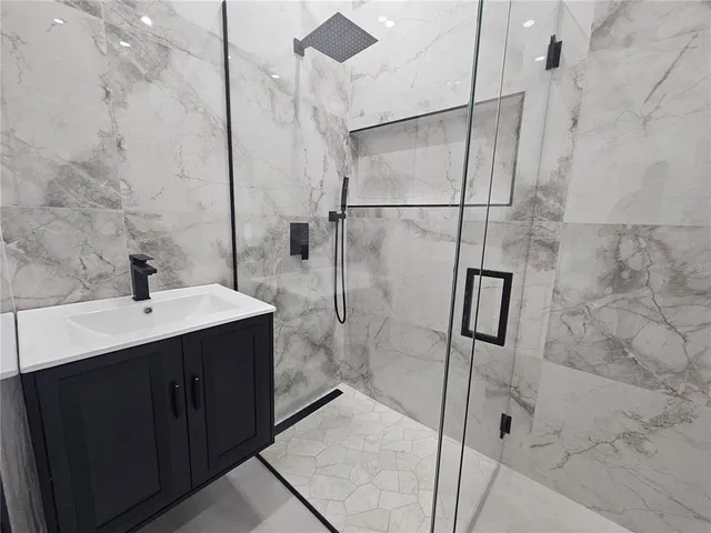 a bathroom with a shower sink and mirror