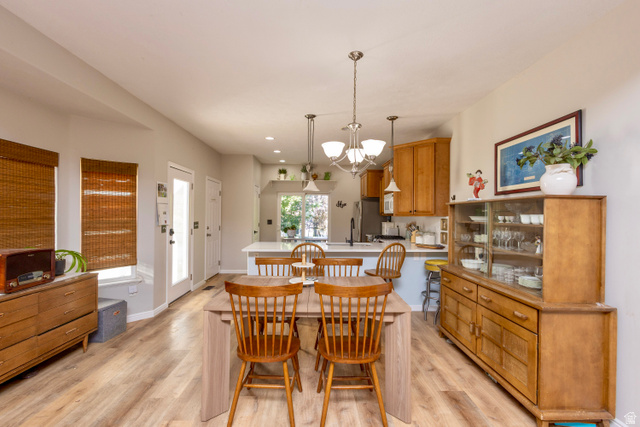 11751 Lake Run Road South Jordan, UT 84009 - Photo 14 of 38 Open-concept dining area with wood-finish flooring, a contemporary chandelier, two exterior doors, and recessed lighting